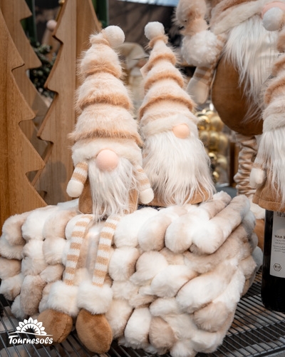 Deux figurines de gnomes aux couleurs douces sur une couverture moelleuse.